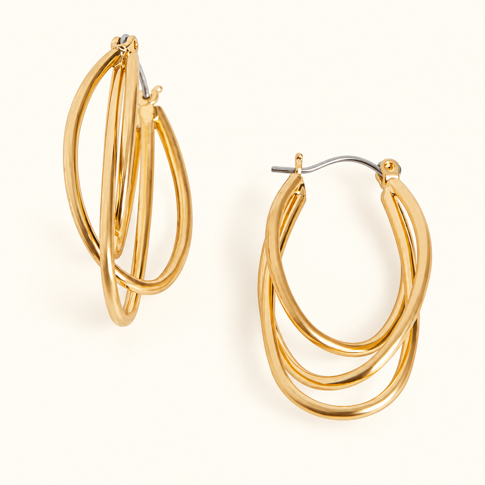 Gold-tone triple hoop earrings featuring three layered oval hoops, a polished finish, and hinged closures in a 1.5-inch design on a cream background.