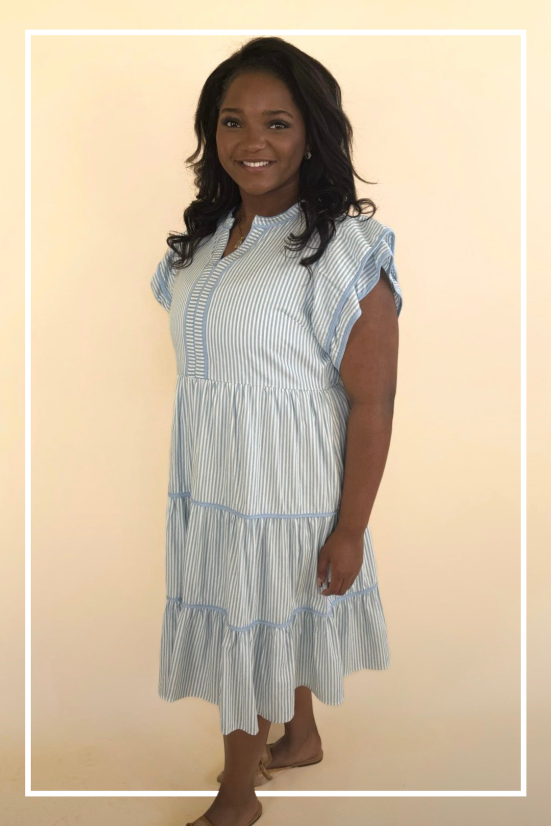 Woman wearing a blue and white striped dress against a beige background | Model - TK | Square 1 Boutique