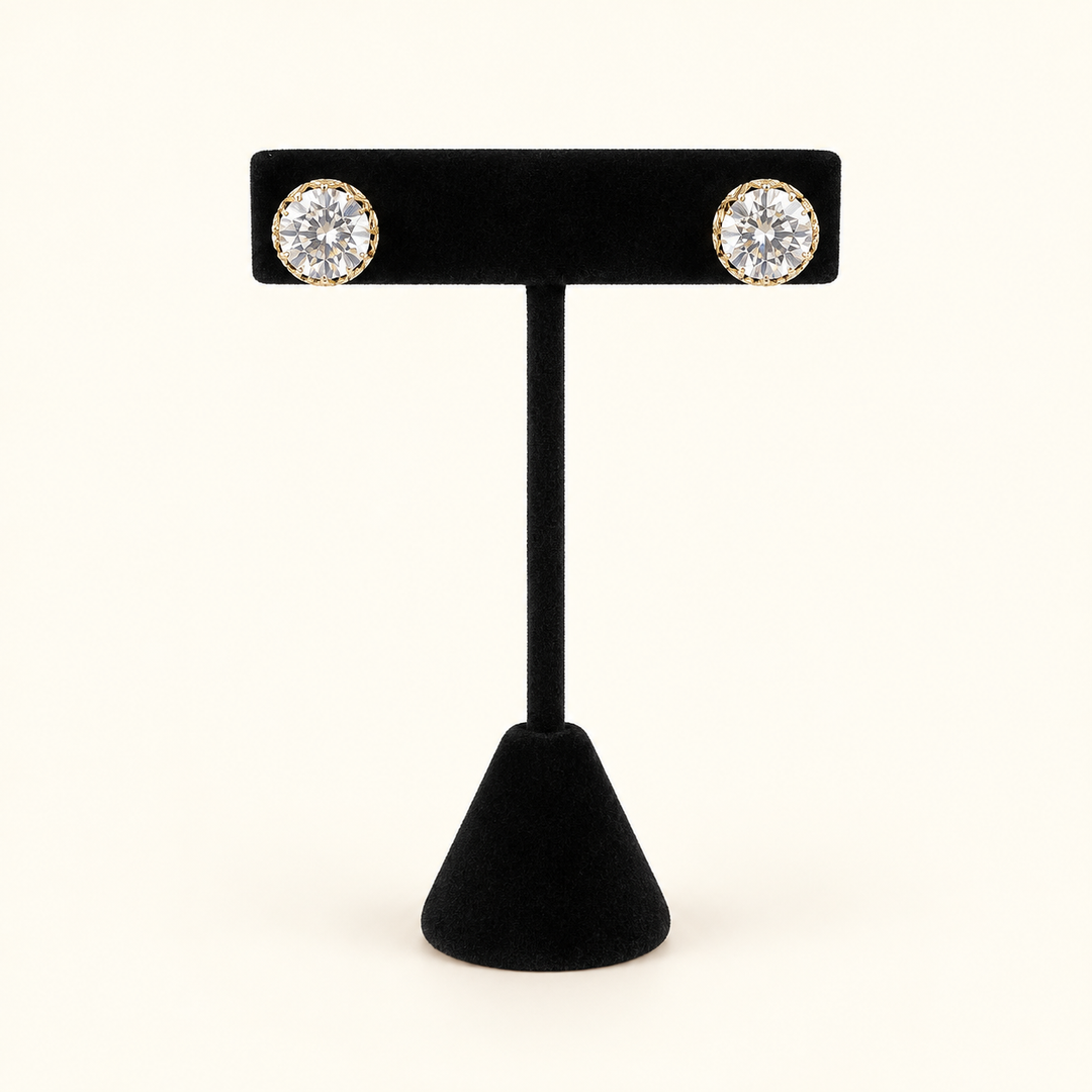 Gilded Glow 10mm clear faceted glass bead stud earrings in gold-tone settings displayed on a black velvet jewelry stand.