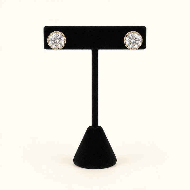 Gilded Glow 10mm clear faceted glass bead stud earrings in gold-tone settings displayed on a black velvet jewelry stand.