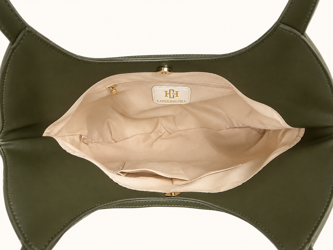 Interior view of the Caroline Hill Greyson Tote in olive showing the beige lining, zippered pocket, two open pockets, and magnetic closure.