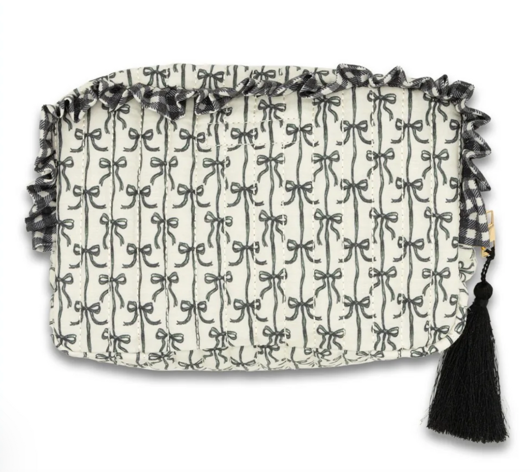 Back view of the Simply Southern Black Bow Quilted Cosmo Bag featuring the allover black bow print, quilted construction, ruffle trim, and black tassel zipper pull on a white background.