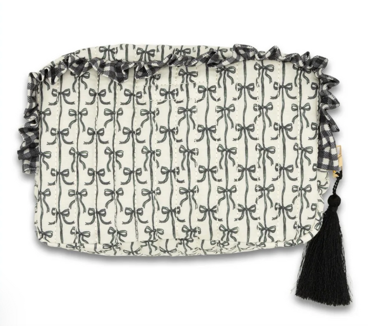 Back view of the Simply Southern Black Bow Quilted Cosmo Bag featuring the allover black bow print, quilted construction, ruffle trim, and black tassel zipper pull on a white background.