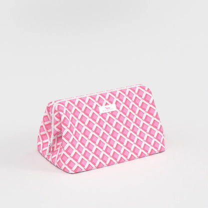 Side view of Big Mouth Makeup Bag in Garden Gate pink lattice print, wide-base cosmetic bag with zip-top closure.