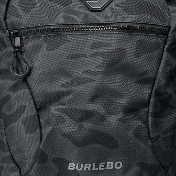 Close-up of the Burlebo Black Camo backpack front zipper pocket highlighting the textured camo pattern, durable fabric, and Burlebo logo.