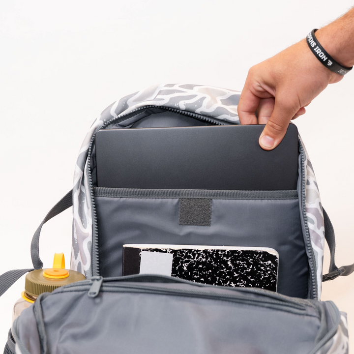 Open Burlebo White Camo backpack displaying the padded laptop sleeve designed to securely fit a laptop or tablet.