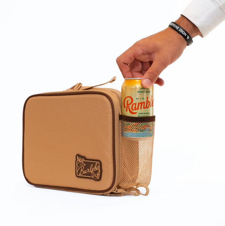 Burlebo Coyote Tan lunchbox featuring a side mesh pocket holding a beverage can, insulated construction, and convenient carry handle on a white studio background.