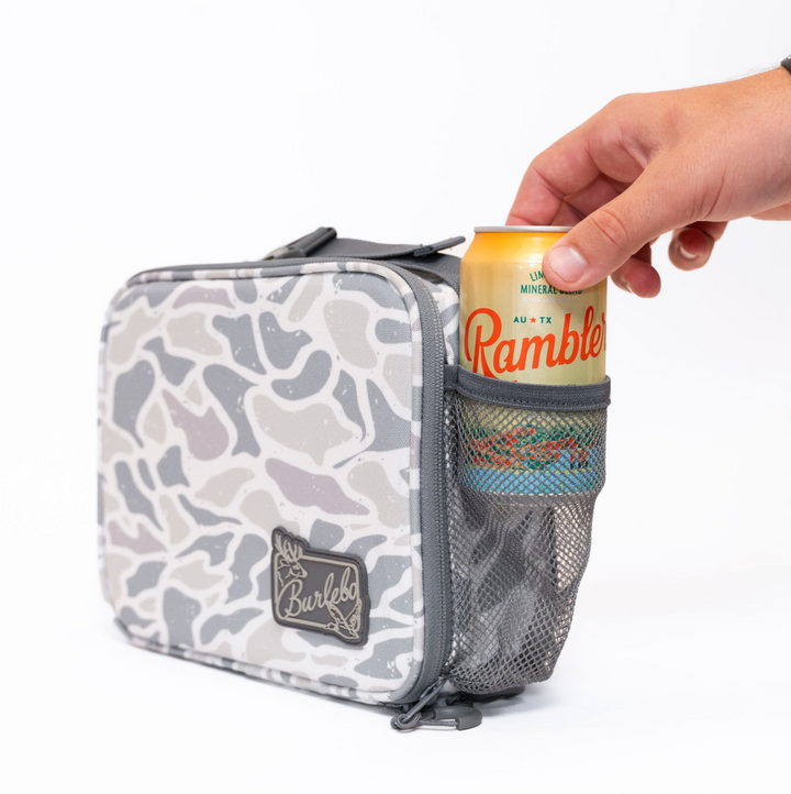 Burlebo White Camo lunchbox featuring a side mesh pocket holding a beverage can, insulated construction, and convenient carry handle on a white studio background.