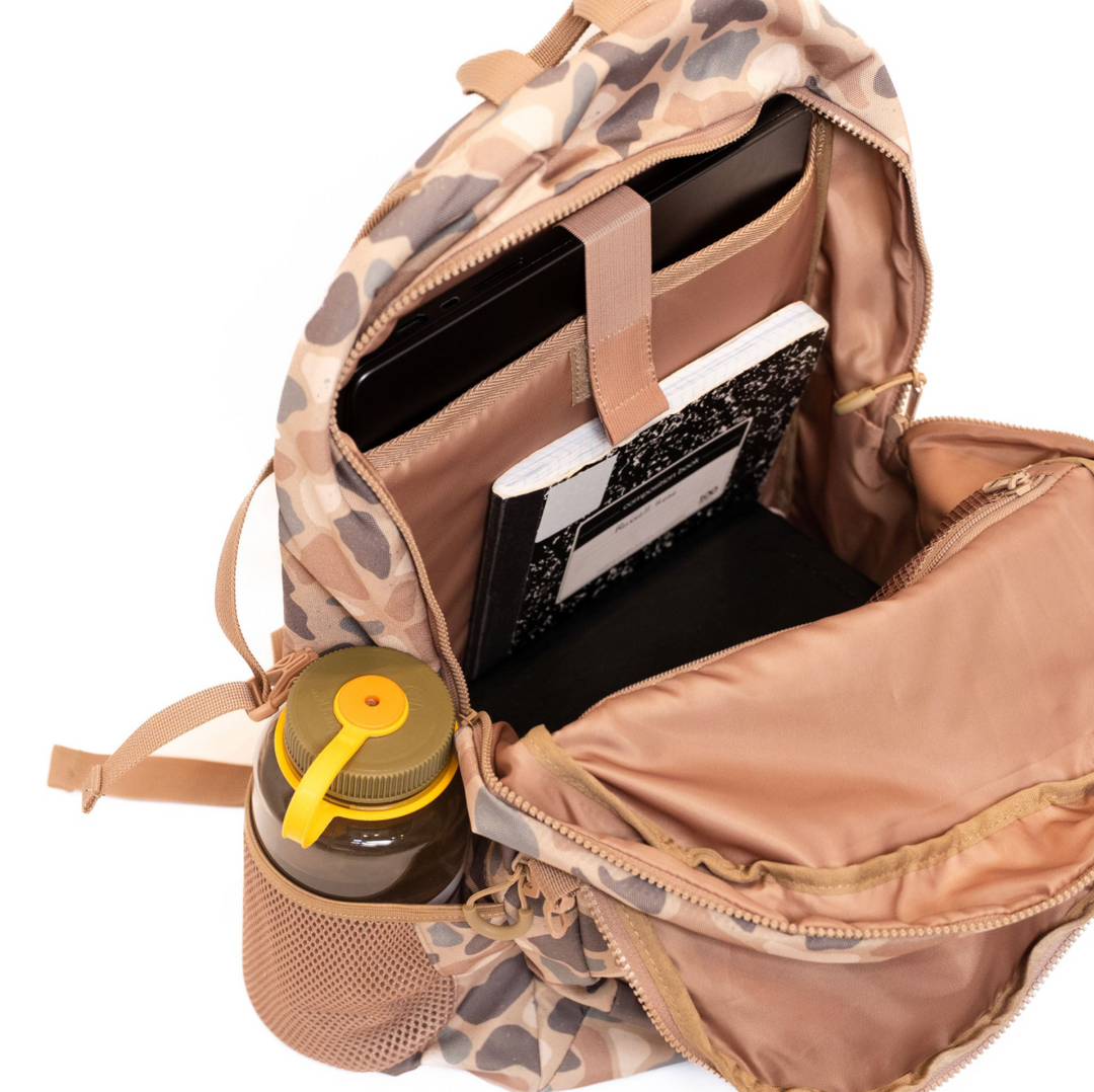 Open Burlebo Pintail Camo backpack displaying the spacious main compartment with padded laptop sleeve and organized interior storage.