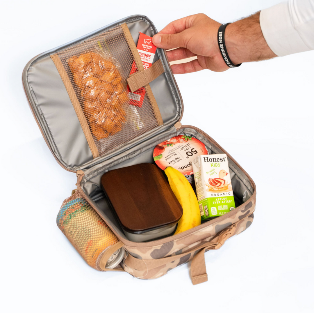 Open Burlebo Pintail Camo lunchbox displaying the insulated interior, mesh storage pocket, snack organization, and spacious compartment for meals and drinks.