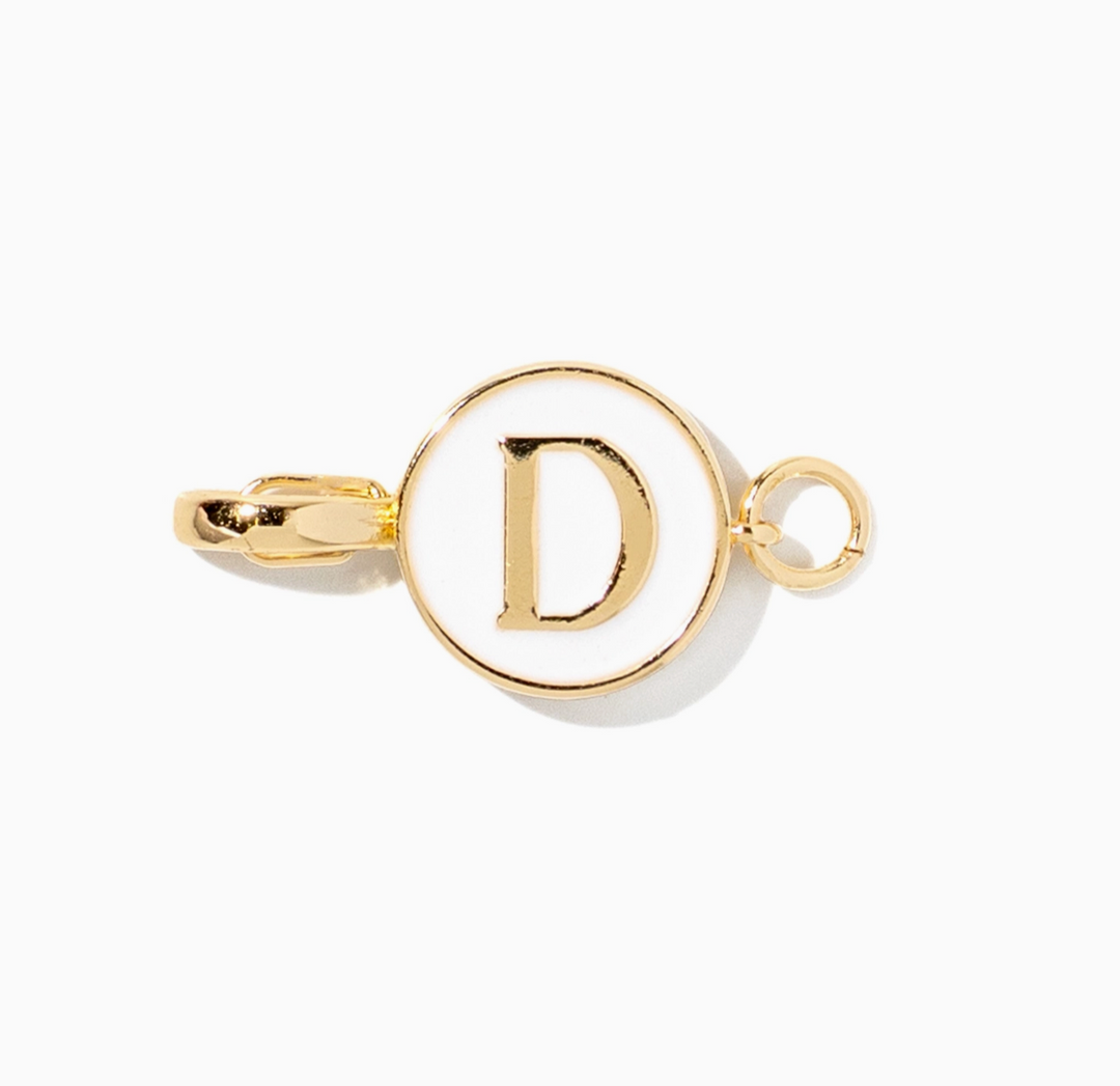 A gold-toned metal initial charm featuring a capital letter &