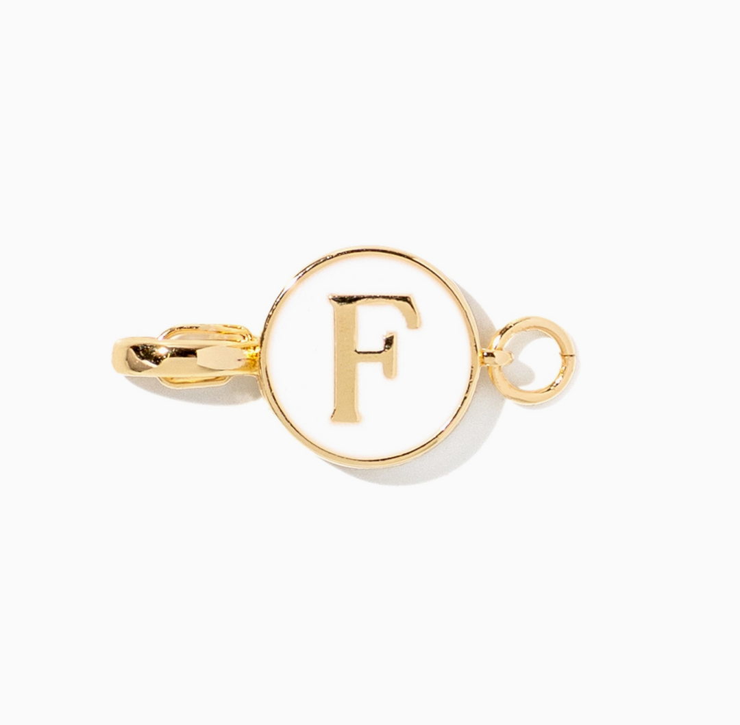 A gold initial charm featuring the letter &