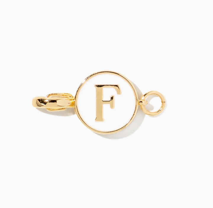 A gold initial charm featuring the letter &