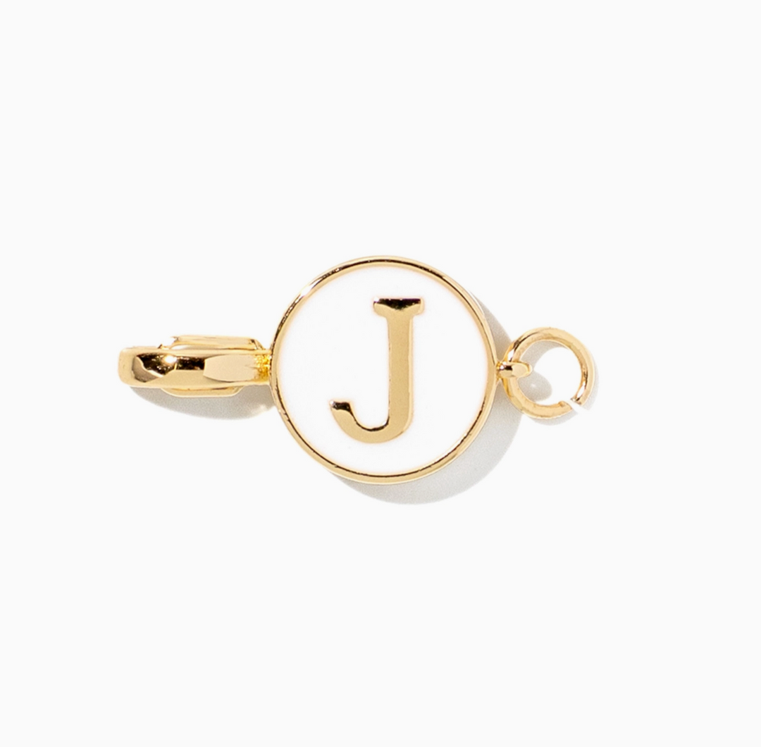 A gold-toned initial pendant charm featuring the letter &