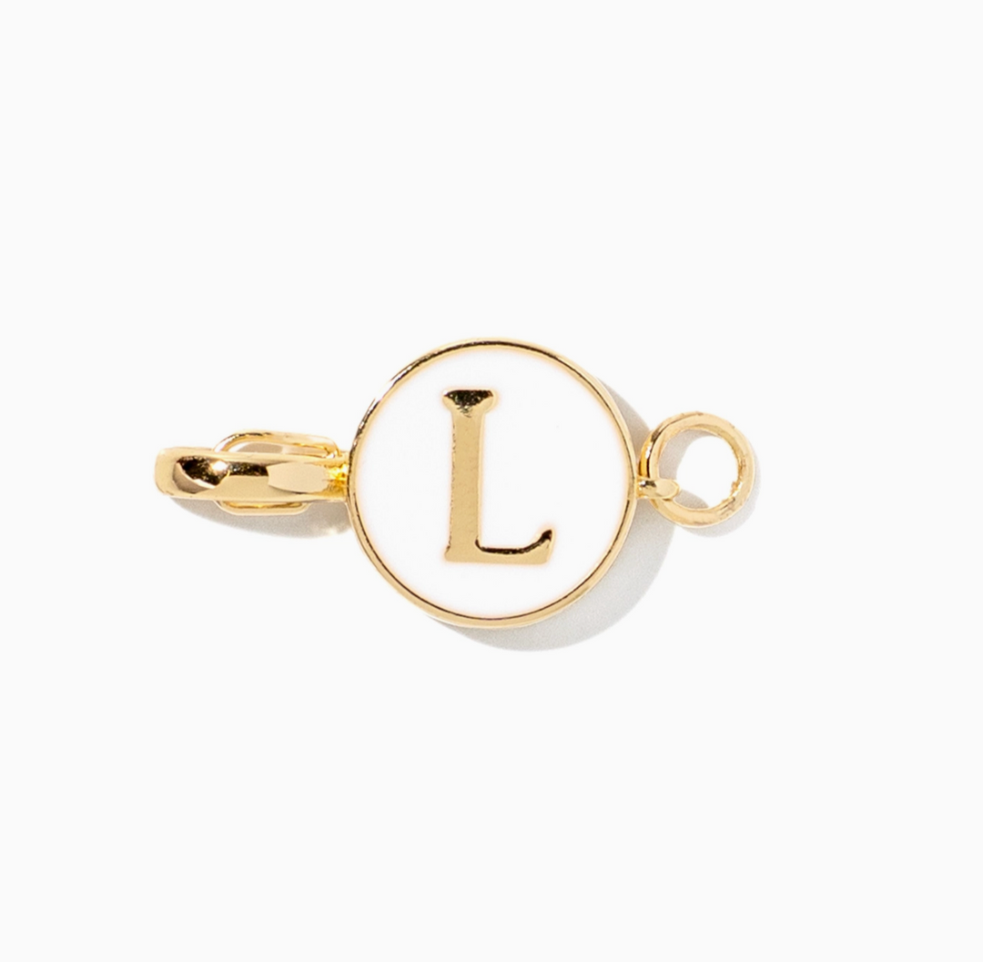 A gold initial charm featuring the letter &