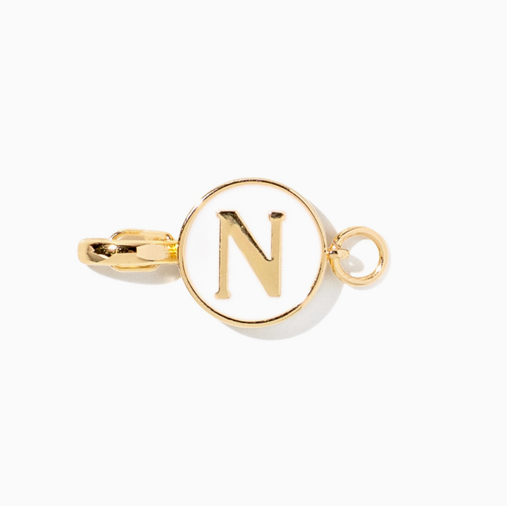 A gold initial charm featuring the letter &