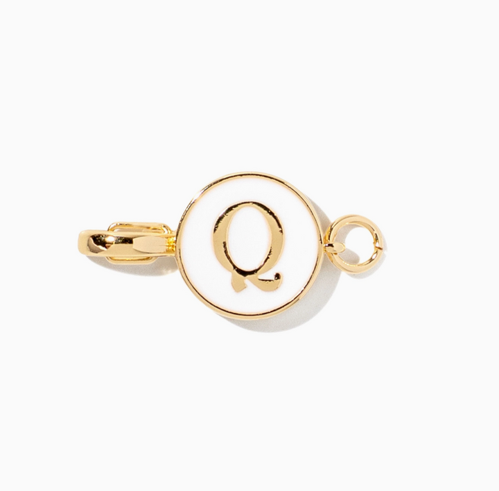 A gold initial charm featuring the letter &