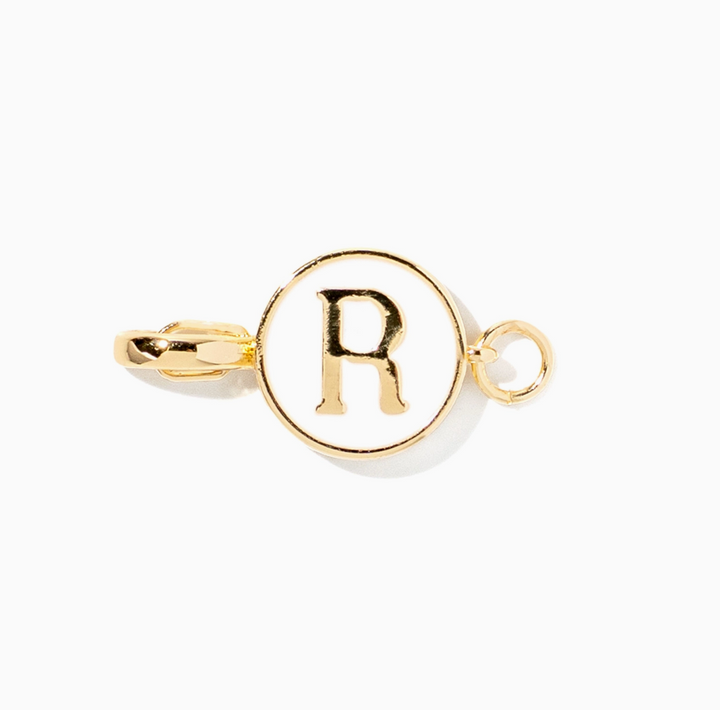 A gold initial charm featuring the letter &