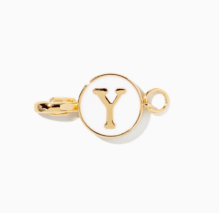 A gold initial charm featuring the letter &