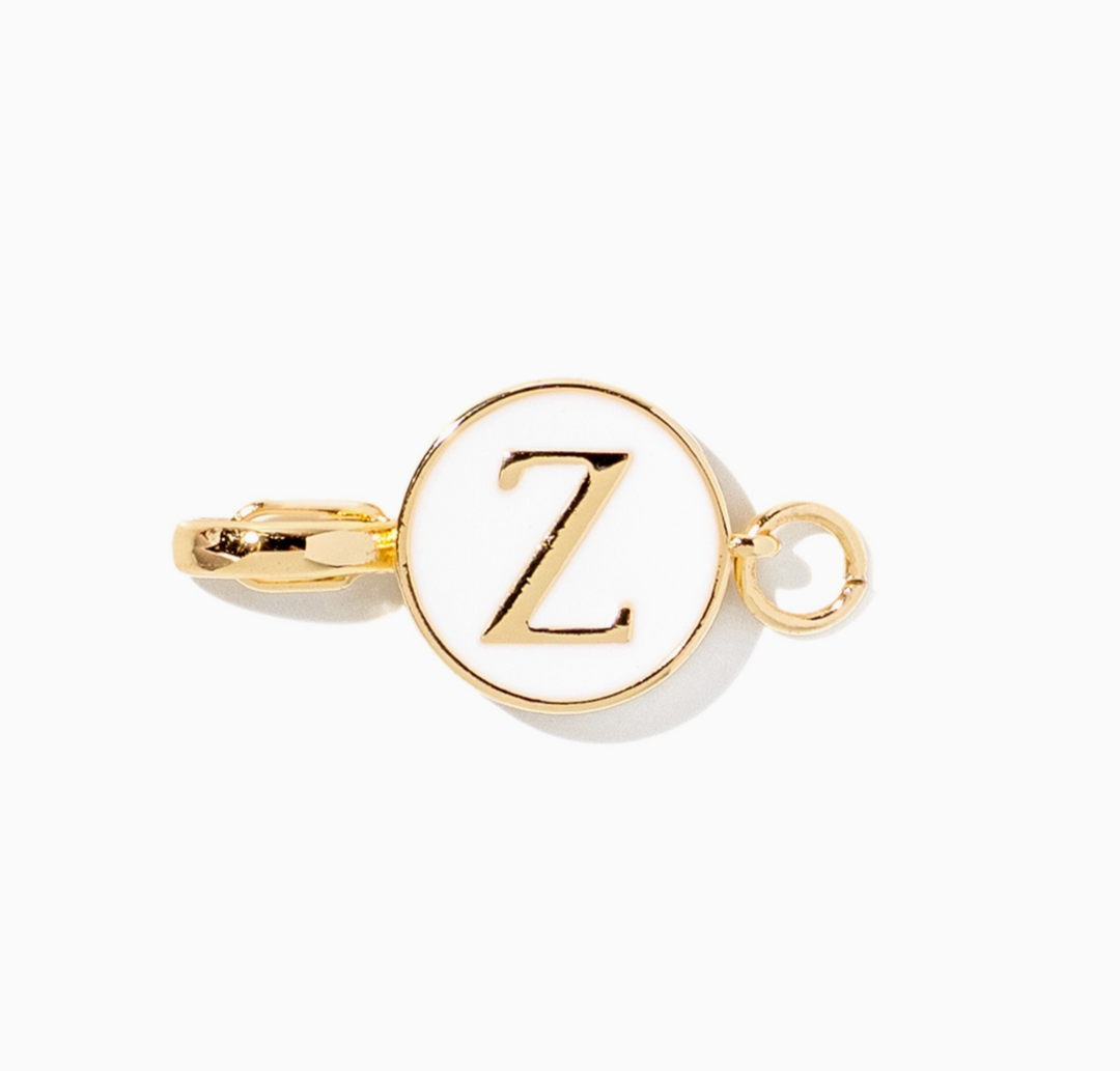 A gold initial charm featuring the letter &
