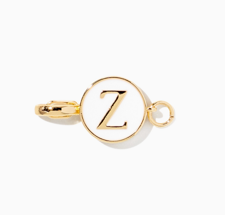 A gold initial charm featuring the letter &