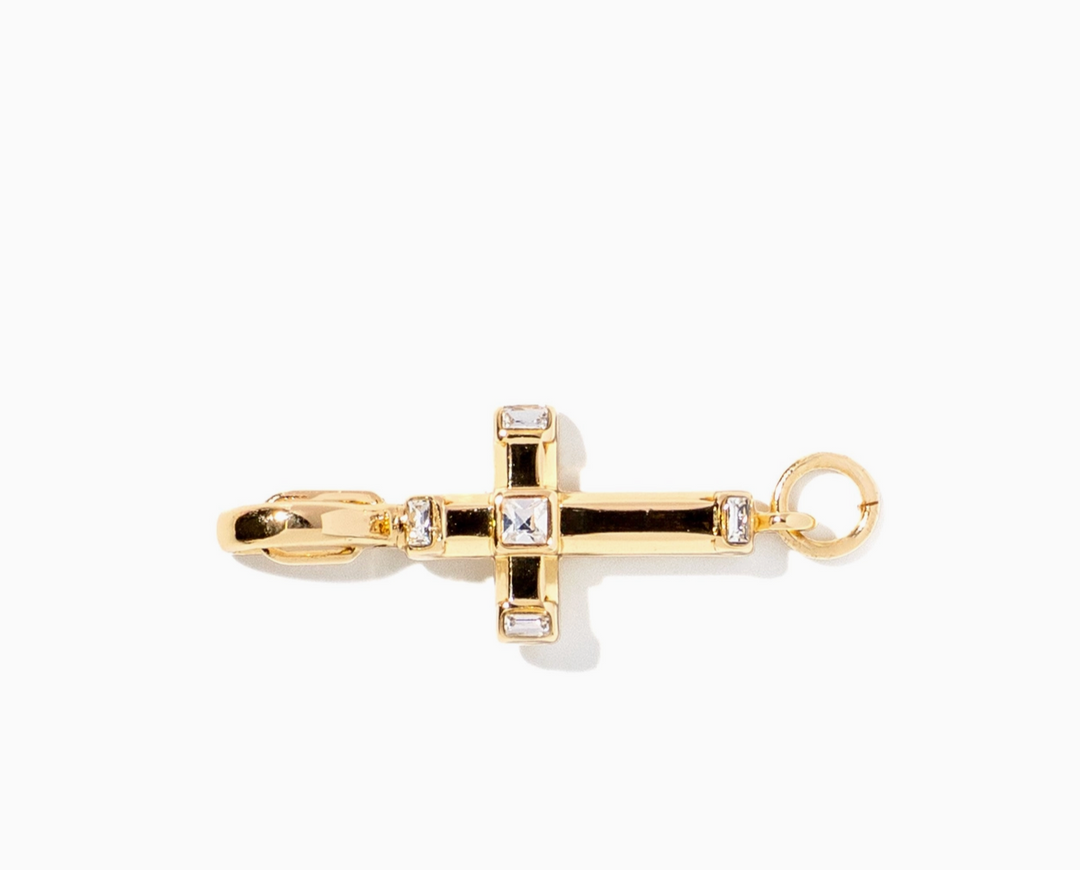 A gold cross-shaped pendant charm with a lobster clasp on one end and a hanging loop on the other, accented with small clear gemstones, shown on a plain white background.