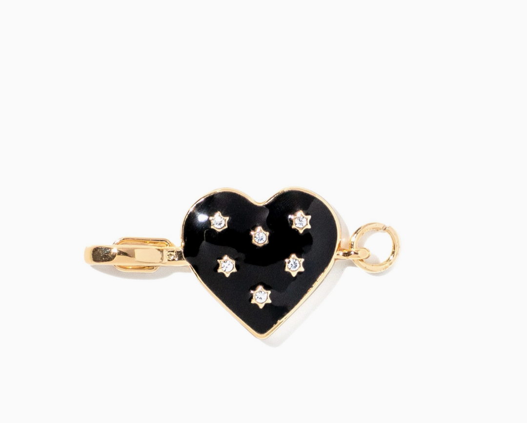 A gold heart-shaped pendant charm with a glossy black enamel center, decorated with five small clear rhinestones, shown on a plain white background.