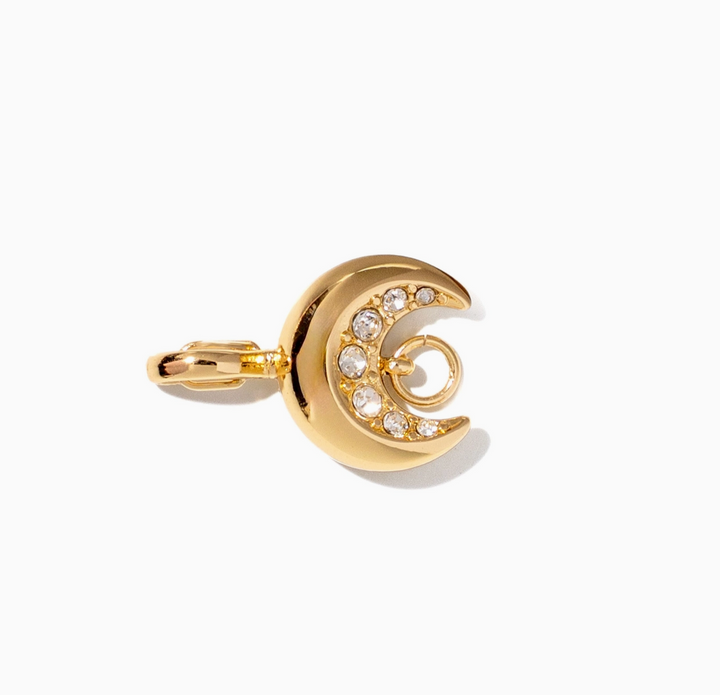 A gold crescent moon charm with a row of clear rhinestones, shown on a clean white background.