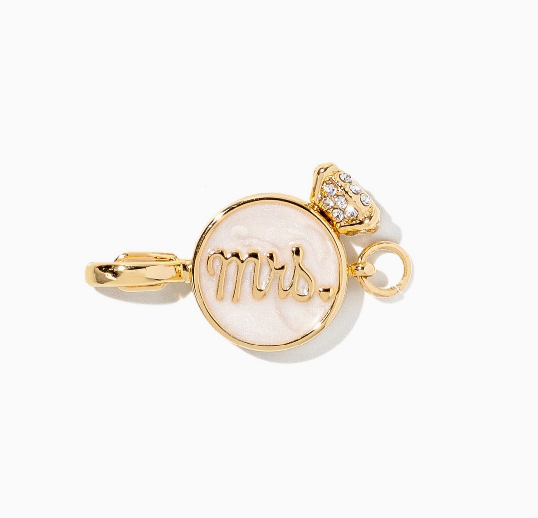 A gold signet pendant charm featuring a round white mother-of-pearl face with the word &