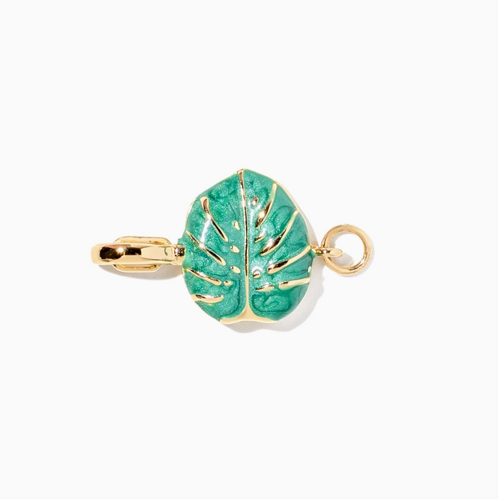 A gold-toned leaf-shaped pendant charm with a textured turquoise green enamel center, shown on a plain white background.