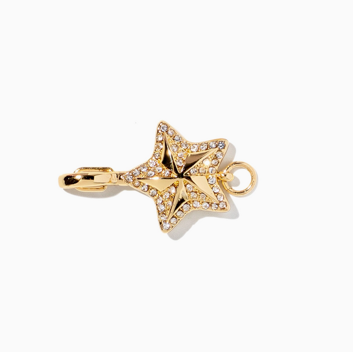 A gold star-shaped jewelry charm embellished with clear rhinestones, featuring a lobster clasp on one end and a hanging loop on the other, set against a plain white background.