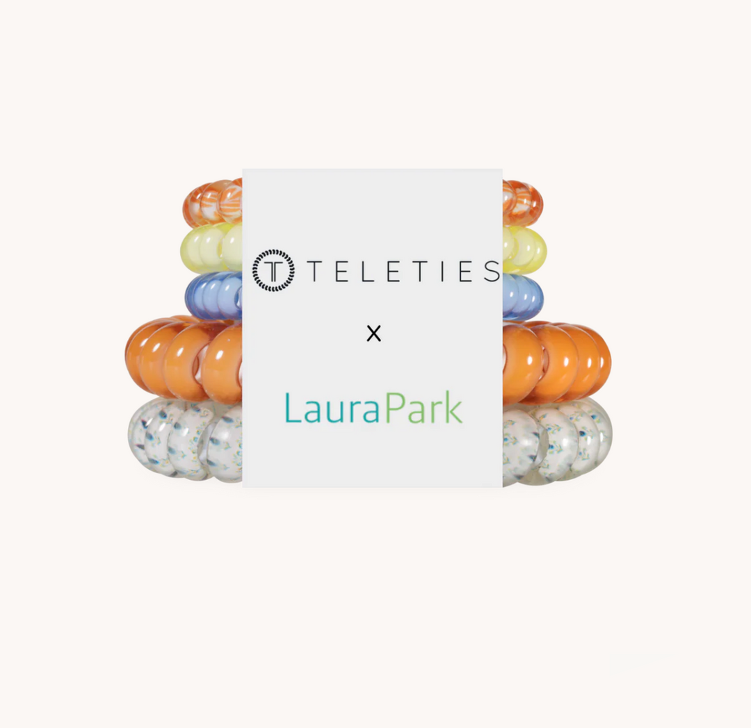 A product bundle of silicone baby teething rings from Teleties and LauraPark, featuring a central white card with the brand logos and a stack of colorful rings behind it on a light beige background.