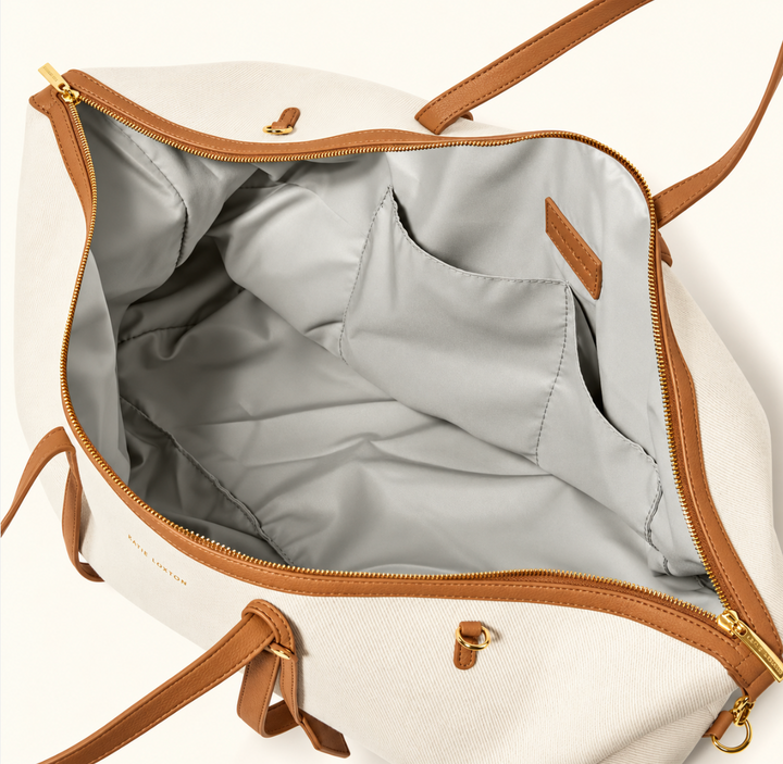 Interior of Katie Loxton Capri Canvas Weekender Bag showing spacious grey lining, organizer pockets and gold zip closure