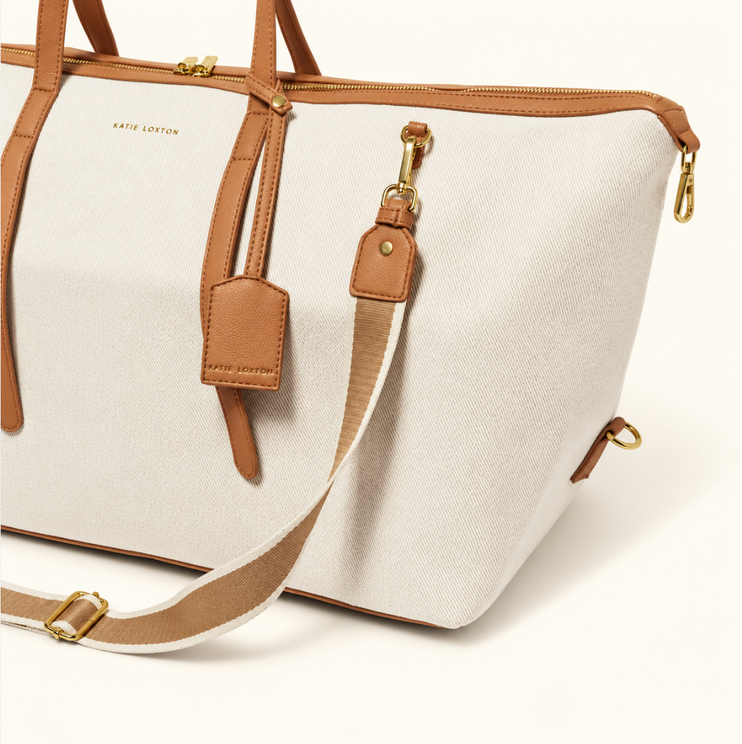 Katie Loxton Capri Canvas Weekender Bag detail with adjustable striped shoulder strap, luggage tag, tan trim and gold hardware