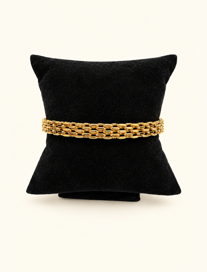 Katie Loxton Braid Chain Bracelet in gold displayed on black velvet jewelry pillow against a cream studio background