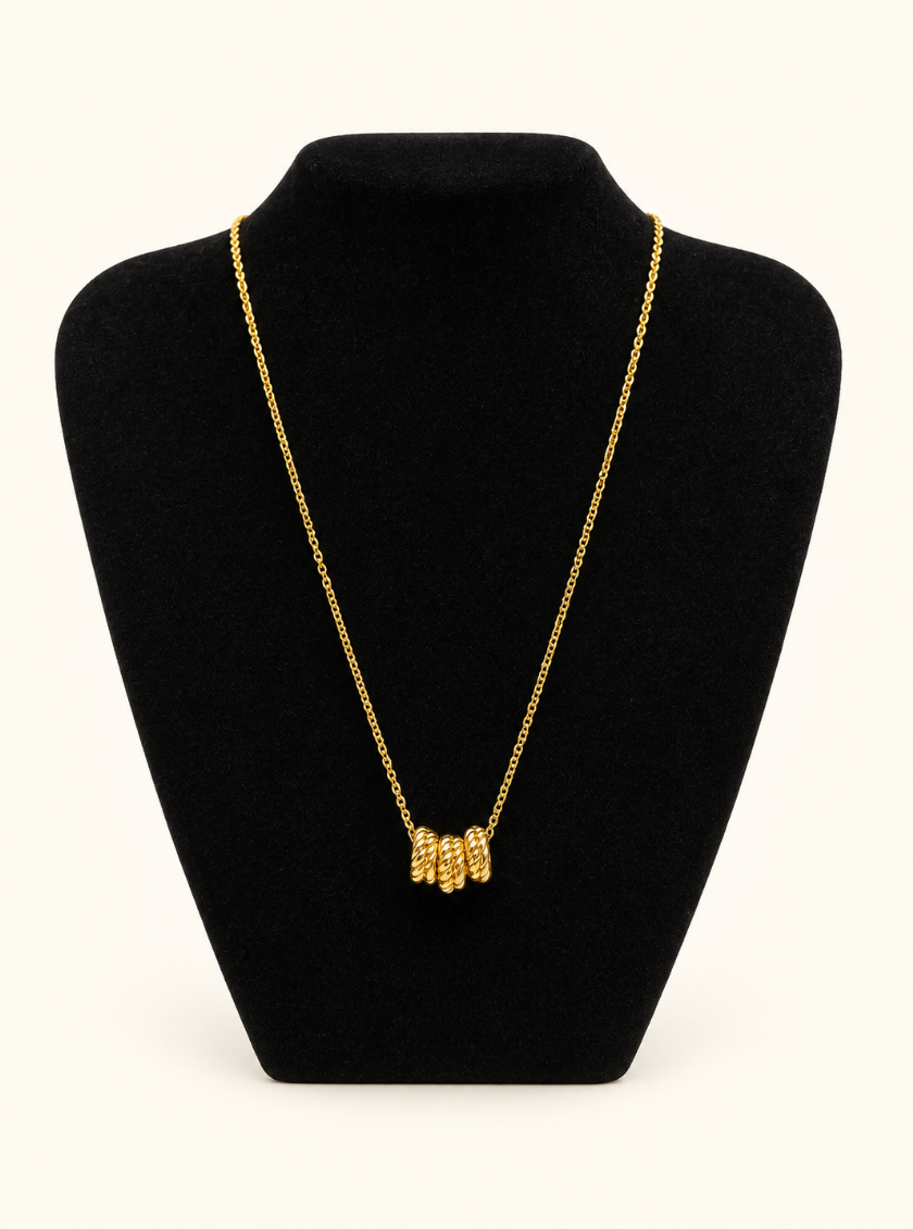 Katie Loxton Laia Necklace in gold displayed on black velvet jewelry stand against a cream studio background