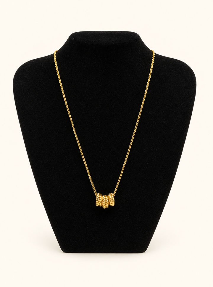 Katie Loxton Laia Necklace in gold displayed on black velvet jewelry stand against a cream studio background