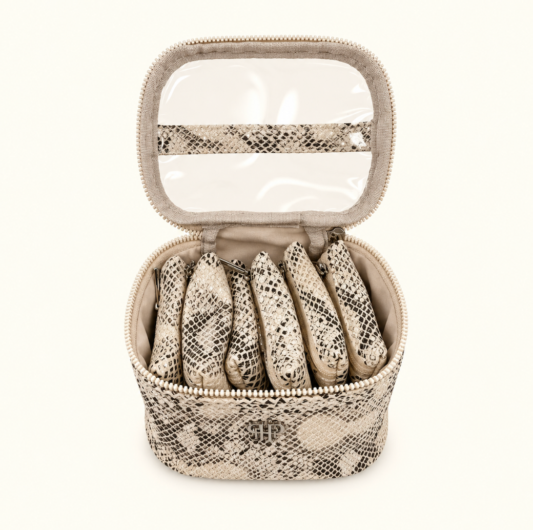 Open Safari Sands Getaway Jewelry Case featuring six removable python print jewelry pouches, cream microsuede lining, and clear-view lid on a cream background.
