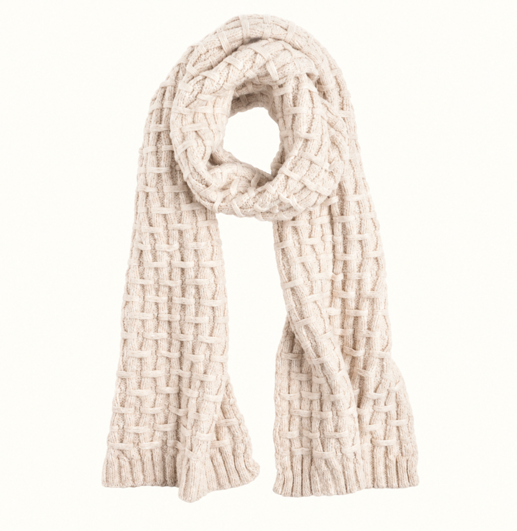 CoCo + Carmen cream chunky knit winter scarf featuring a close-up view of its woven basket-weave pattern, soft textured yarn, and thick ribbed edges against a neutral cream background.
