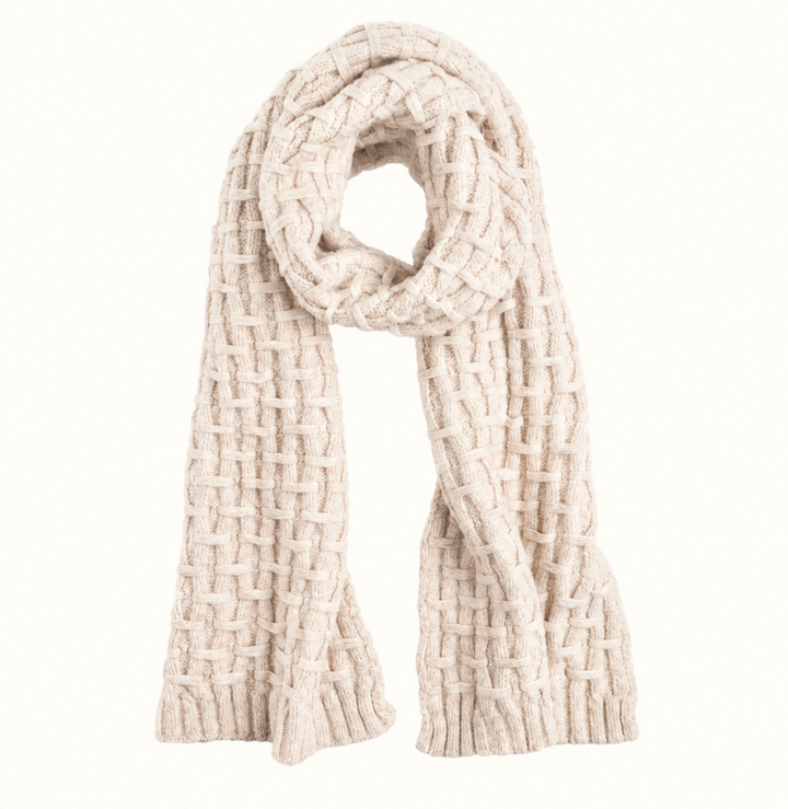 CoCo + Carmen cream chunky knit winter scarf featuring a close-up view of its woven basket-weave pattern, soft textured yarn, and thick ribbed edges against a neutral cream background.