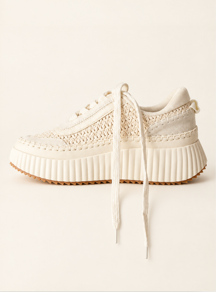 Cream Dolea Platform Sneaker featuring a woven knit upper, lace-up design, textured stitching, and chunky ribbed platform sole on a cream background.