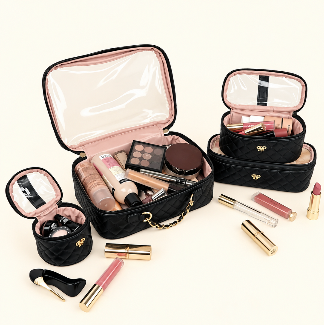 Black quilted makeup and travel organizer set featuring multiple open cosmetic bags filled with makeup, skincare, and beauty essentials, with gold hardware and blush pink interiors on a cream background.