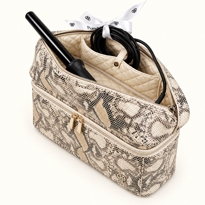 Safari Sands cream python Stylist Travel Bag with open top compartment holding a black curling iron and coiled power cord, featuring cream quilted lining and zippered compartments.