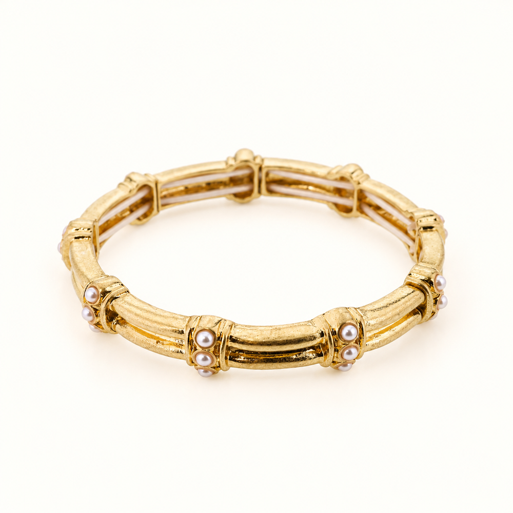 Gianna 8-inch gold pearl accent stretch bangle bracelet featuring textured gold bar details and small white pearl clusters on a cream studio background.
