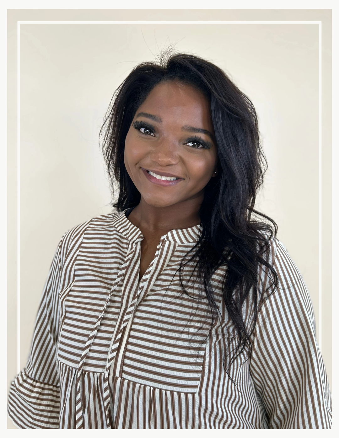 Woman wearing a striped shirt against a plain background
