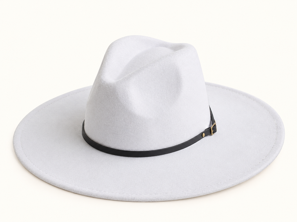 White felt western fedora hat with wide structured brim, pinched crown, and slim black belt-style hat band featuring antique gold buckle detail on a cream studio background.