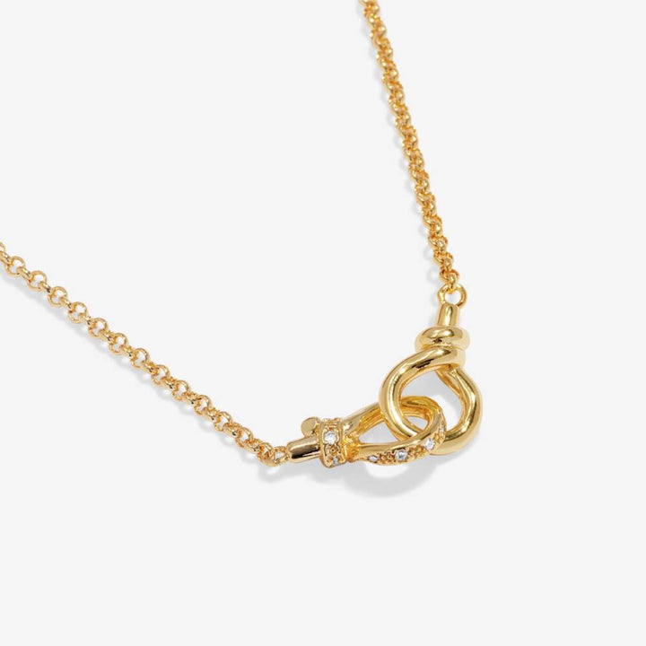 Gold necklace with a unique clasp design on a white background