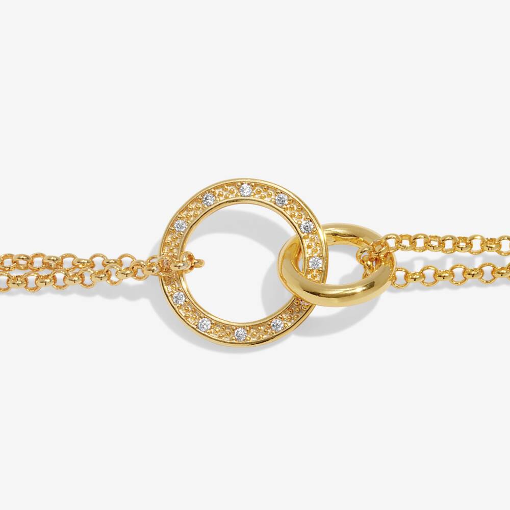Gold bracelet with interlocking rings and diamond accents on a white background