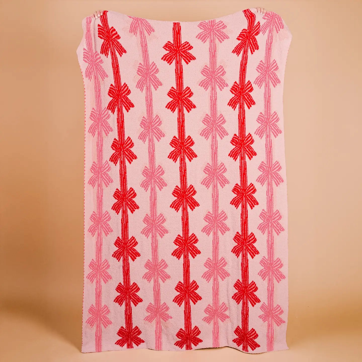 Fabric blanket with red and pink pattern on a beige background