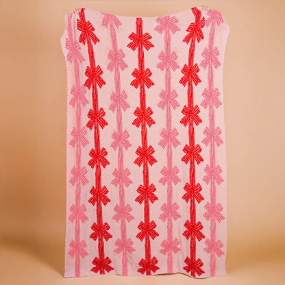 Fabric blanket with red and pink pattern on a beige background